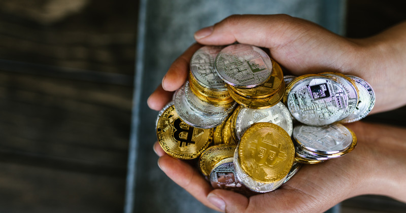 criptovalute, monete in mano
