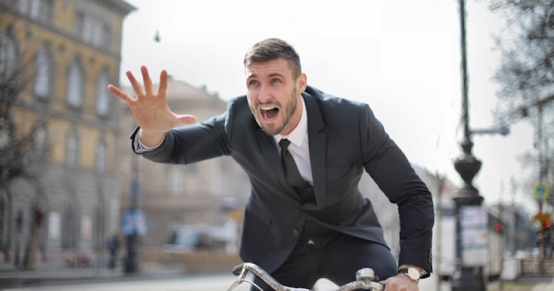 Uomo d'affari in bicicletta di fretta